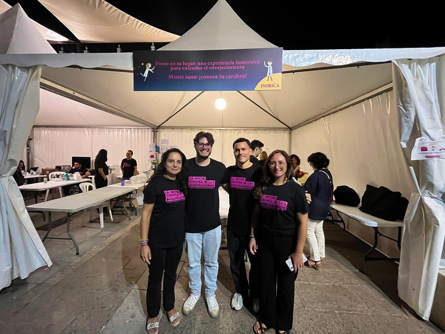 Team members at La Noche Europea de los Investigadores 2025 stand 'Mente Sana: ¡Conoce tu cerebro!' wearing event t-shirts